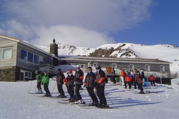 Line of skiers gathered outside the lodge, geared up for the slopes
