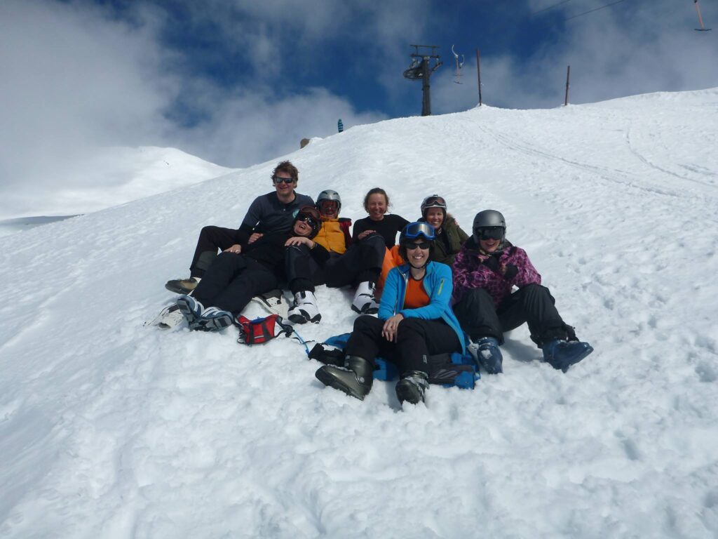 Members relaxing together on the snow after a day on the mountain
